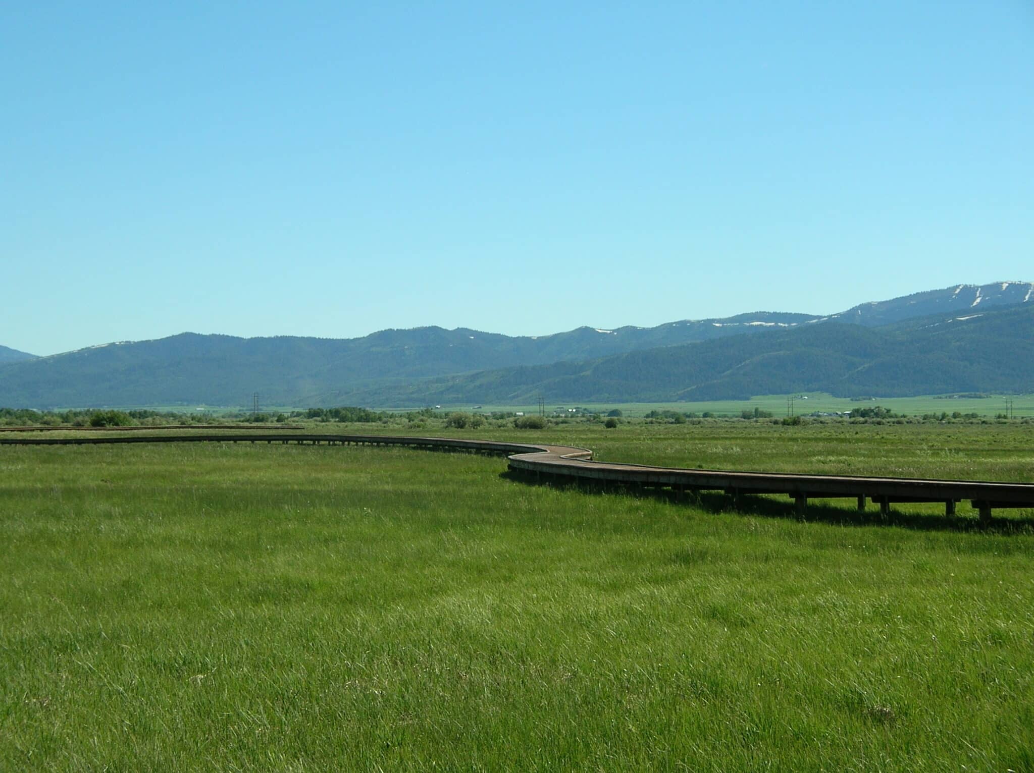 Environmental Significance of Tributary, formerly known as Huntsman Springs springtime boardwalk picture with the Tetons in background built by York Bridge Concepts in Driggs, ID