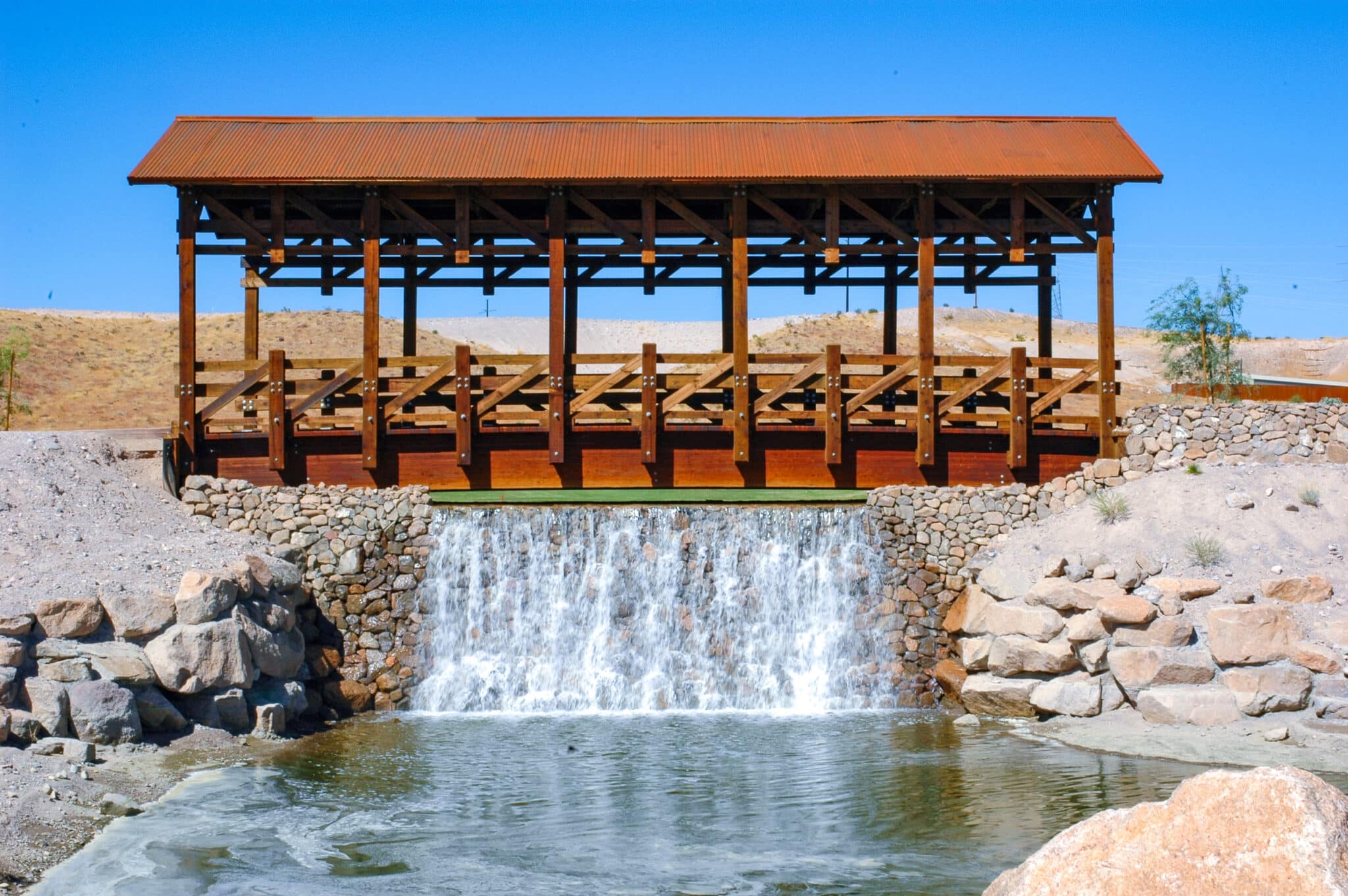 Laughlin Ranch Covered Cart Bridge over a waterfall design-built by York Bridge Concepts in Bullhead City, AZ