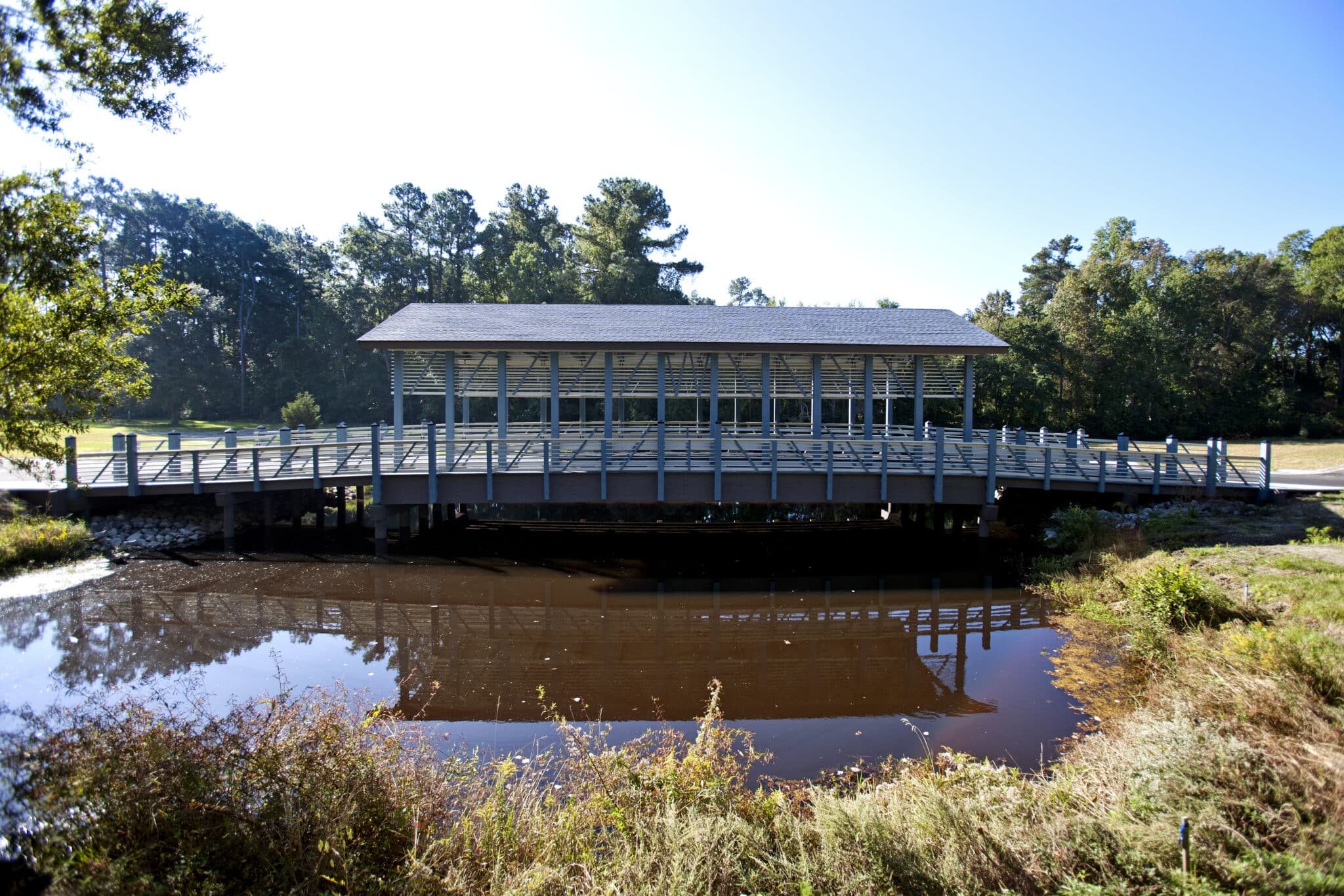 Side shot from ground of The Plantation At Winyah Bay covered vehicular timber bridge in Georgetown, SC