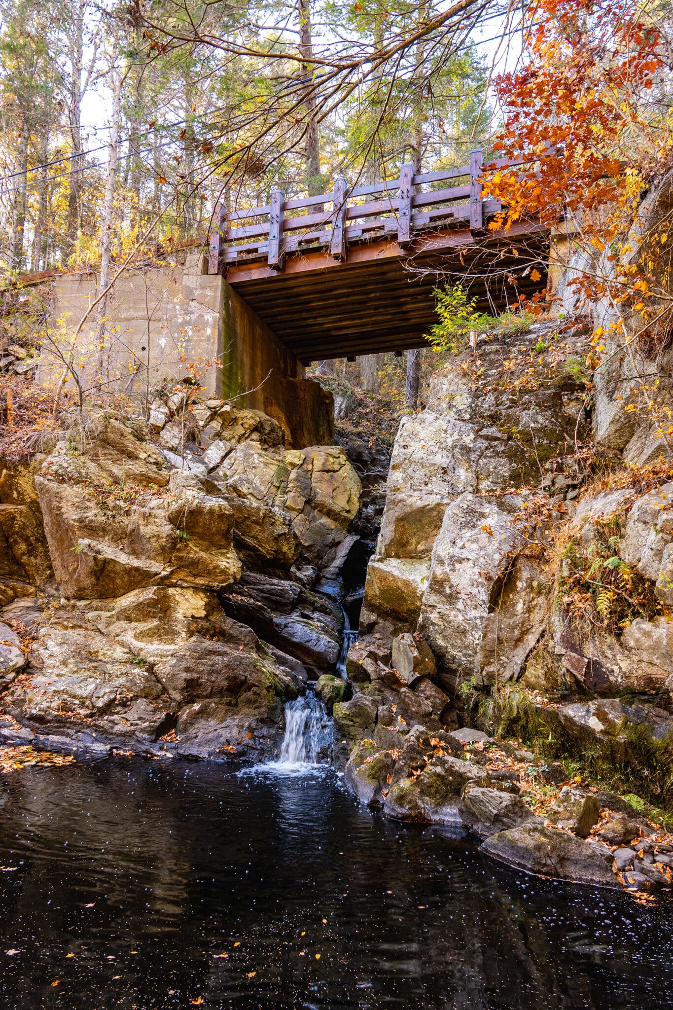 Vertical picture of poverty hollow bridge over waterfall.